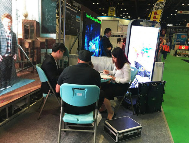 奥兰多橘城会展中心mile米乐集团展位现场，外贸部经理黄勇强和何巧玲与意向客户在交谈中